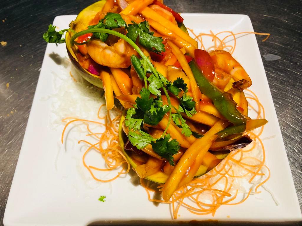 Mango Prawns · Prawns sauteed with fresh shredded mango, pepper in spicy and sour  sauce in mango shell.