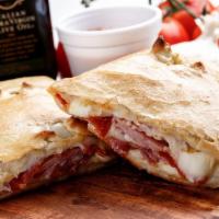 Meat Lover Calzone · Pepperoni, Italian sausage, ground beef, ham, bacon, oregano, and Parmesan cheese.
