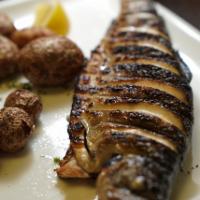 Grilled Trout · Whole, head on Rainbow Trout marinated in Extra Virgin Olive oil and fresh herbs, served wit...