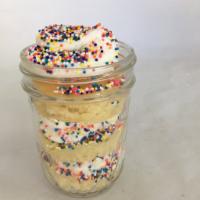 Birthday Cake cupcake in a jar. · Vanilla cake layered with vanilla buttercream frosting and sprinkles served in a mason jar.