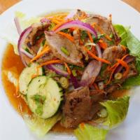 22. Grilled Beef Salad · Grilled beef marinated in chili paste with shallots, scallions, tomatoes, cucumber, roasted ...