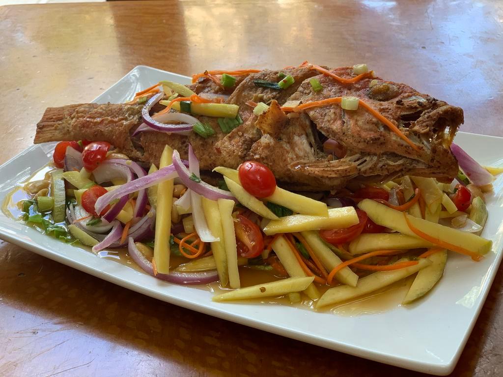 83. Red Snapper Mango Salad · Deep fried whole fish served with mango salad.