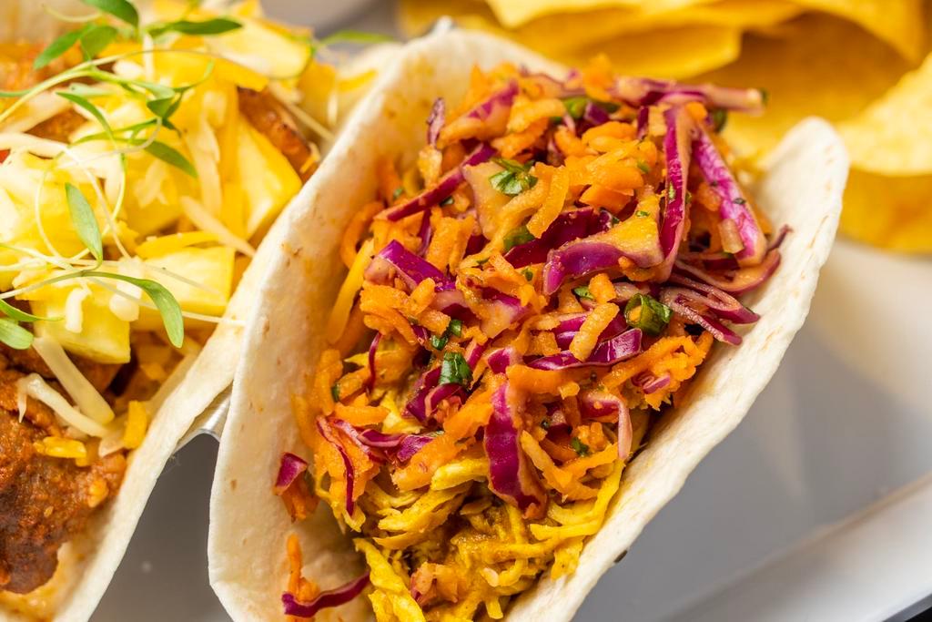Curry Chicken Tinga Taco · Chicken breast slow cooked in Chipotle with Adobo, tomatoes and onions, and then braised in a curry sauce. Topped with Asian slaw, TaKorea greens, and choice of sauce/salsa on the side.  Served in our Gordita crunch shell.
