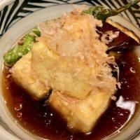 Agedashi Tofu · Fried tofu, eggplant and shishito pepper in dashi stock. Dried bonito flakes on top.