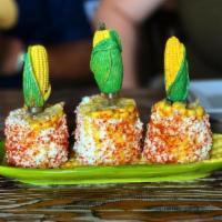Elotes de Feria · Steamed corn on the cob with chili powder, mayonnaise and cotija cheese.
