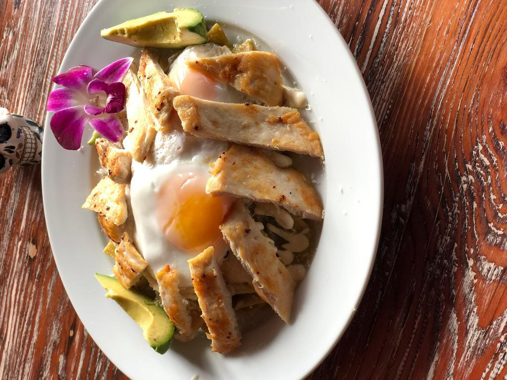 Chilaquiles Verdes · Corn tortilla lightly fried with chicken in tomatillo green sauce. Garnished with onions, Mexican cream, queso fresco and avocado.