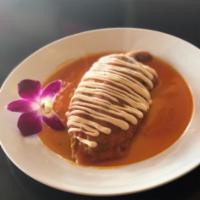 Chile relleno · Roasted poblano pepper stuffed with cheese, in a mild tomato sauce served with rice and beans