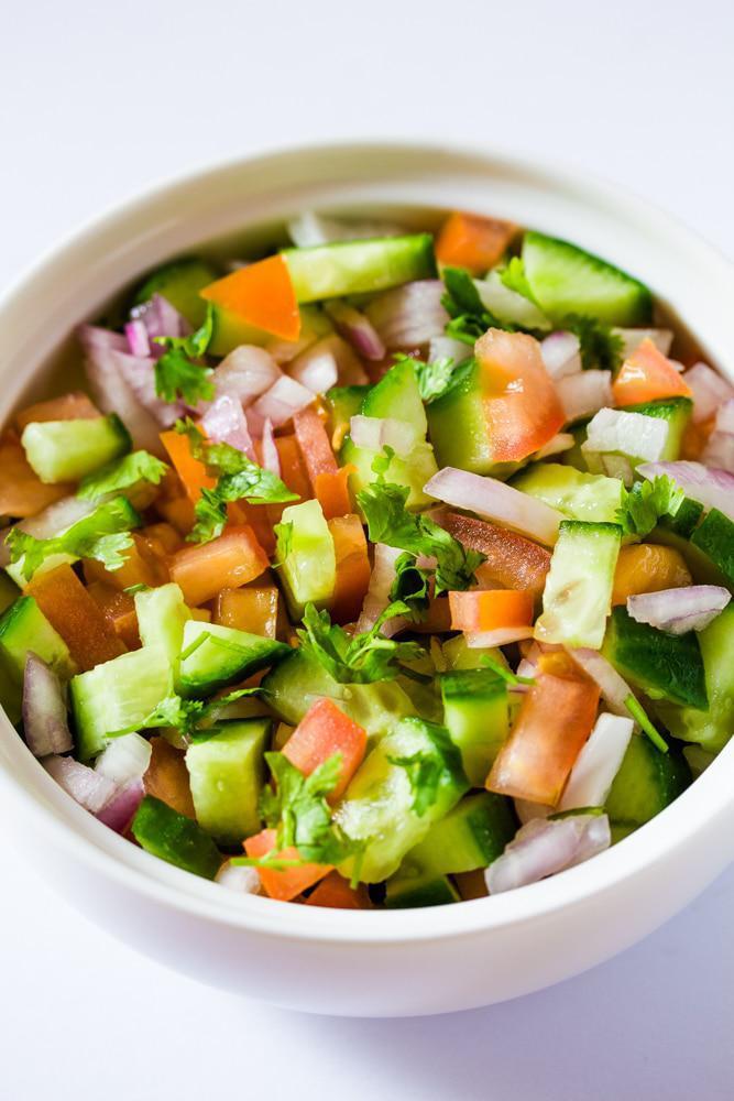 Indian Salad Tossed  · Diced cucumbers, onions, tomatoes, chickpeas, green chili, and freshly squeezed lime juice. Squeezed with house dressing.
