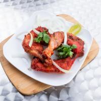 Tandoori Chicken · Bone in thigh meat, chicken pieces marinated and cooked in a tandoor oven sides breads.