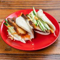 S2. Melt in Your Mouth Pork Belly Bao · Two pieces of steamed bun sandwich with pork belly, carrot, cucumber, cilantro, and peanuts