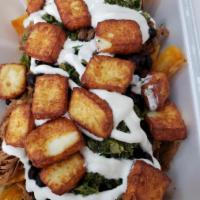 Patacon Pisao Poutine · Yucca fries, layered with shredded beef, black beans, house made sour cream, chimichurri sau...