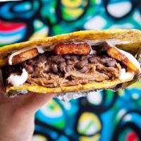 De Pabellon Patacon · Smashed plantain sandwich stuffed with lack beans, shredded beef, sweet yellow plantain, and...
