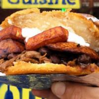 Arepa De Pabellon · Black beans, shredded beef, sweet yellow plantains, and shredded queso blanco topped with na...