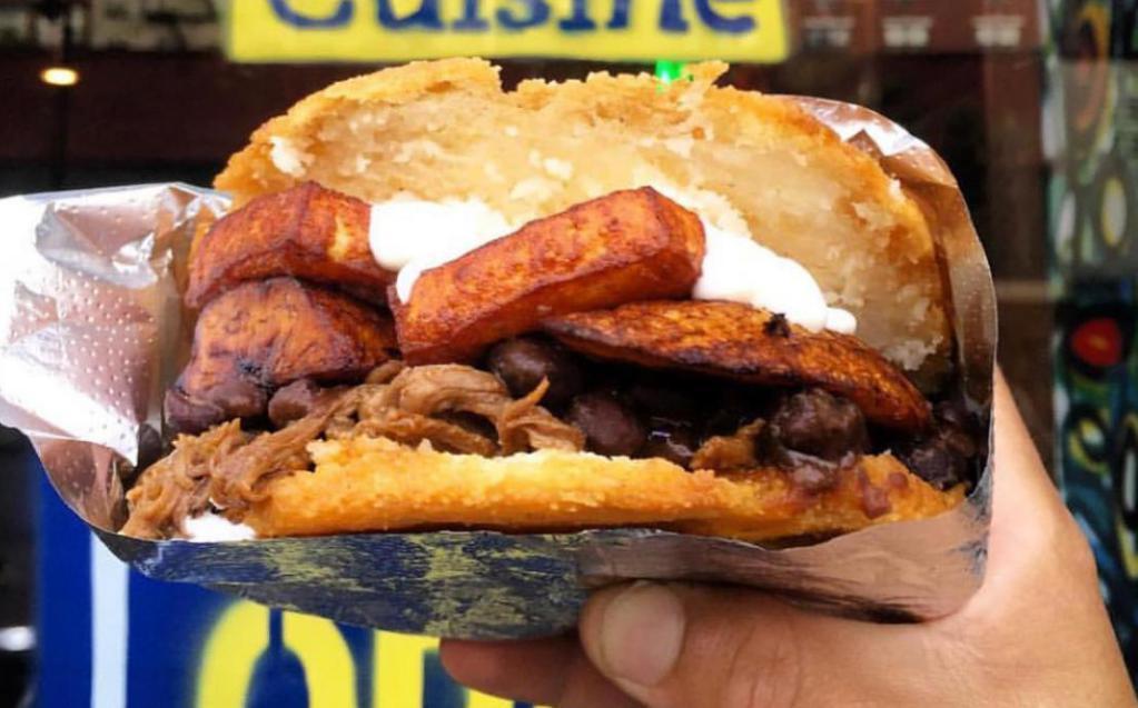 Arepa De Pabellon · Black beans, shredded beef, sweet yellow plantains, and shredded queso blanco topped with nata.