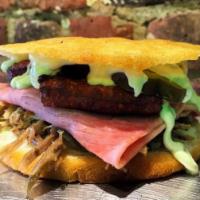 Arepa Cubana · Pulled roasted pork, ham, fried queso blanco, half sour pickle, and salsa verde.
