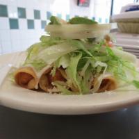 Flautas de Pollo · Hard-shelled fried tacos filled with chicken topped with sour cream, cheese, onion, tomato, ...