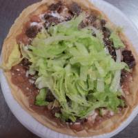 Huarache con Carne · Home made tortilla topped with beans, sour cream, cheese, lettuce and choice of meat.