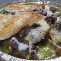 Chillaquiles con Carne y Huevos · Tortillas chips drenched in green or red sauce topped with cheese, meat and eggs.