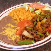 Steak Ranchero · Steak in a spicy sauce served with rice, beans, salad and tortillas.