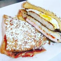 Sin City Breakfast Sandwich · Ham, sausage, hash browns, fried egg and raspberry jam on Texas toast dusted with powdered s...