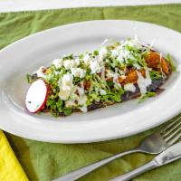 Huarache Al Pastor · Oval real corn tortilla topped with refried beans, meat of choice, lettuce, Cotija cheese an...