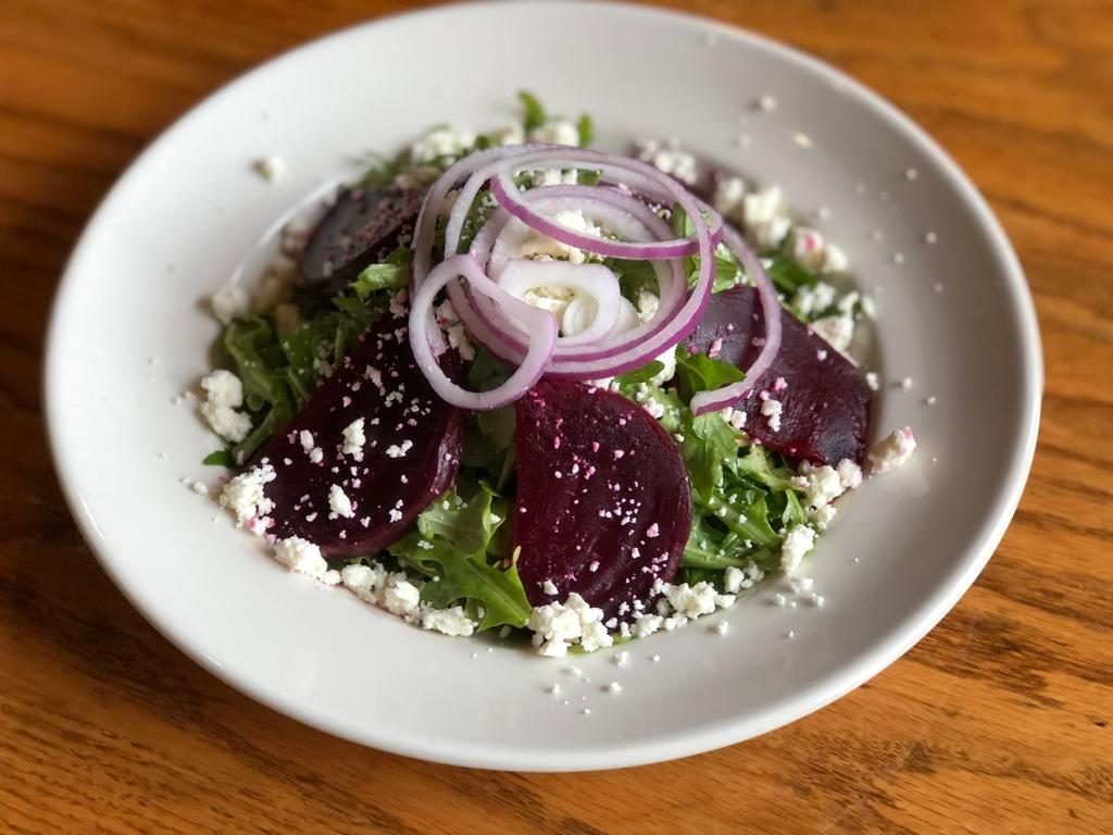 Roasted Beet and Arugula Salad · Roasted beets, arugula, and red onion tossed with lemon vinaigrette and topped with feta cheese.