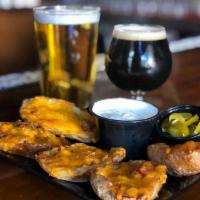 Potato Skins · Potato skins filled with bacon and cheddar. Served with a side of sour cream and jalapenos.