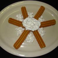 Churros · 6 delicious Mexican pastries with cinnamon and sugar. Topped with honey and whipped cream.