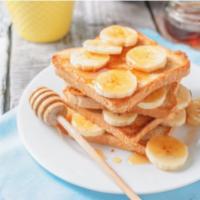 Banana French Toast · Sliced challah bread soaked in eggs and milk, then fried and topped with bananas.