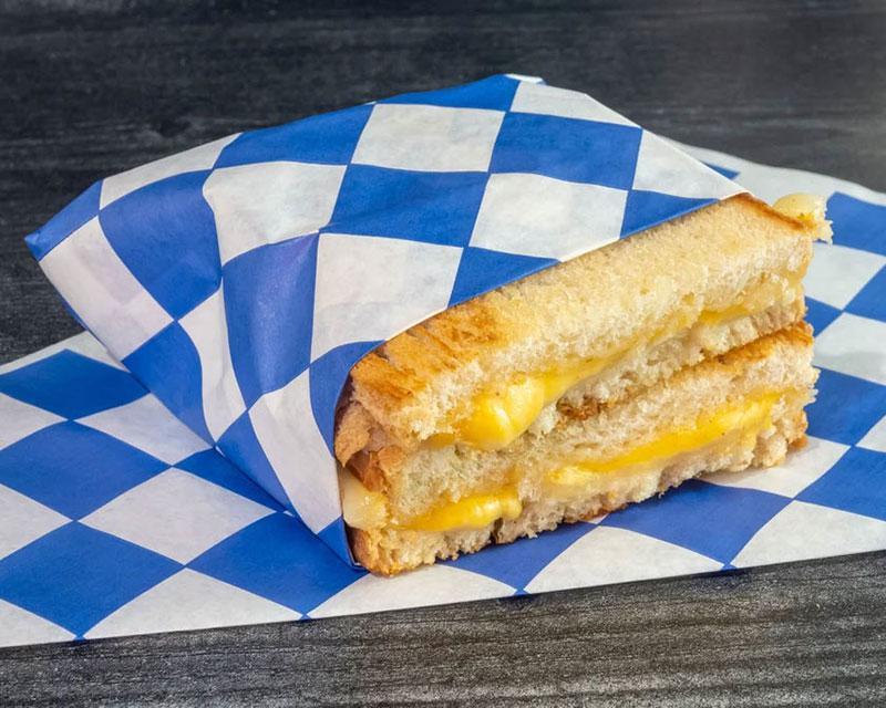 Grilled Cheese Sandwich · Swiss & American cheeses, butter, mayo, sliced sourdough.