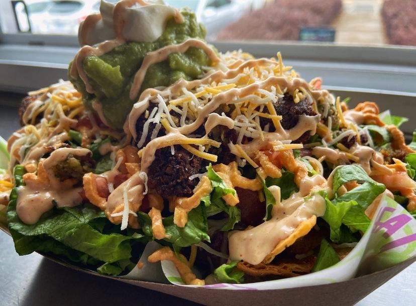 Southwest Loaded Nachos · Choice of corn chips, curly fries, or tots. Shredded cheese, (v) warm three-bean chili, green leaf, pico de Gallo, sour cream, Taza sauce. Add vegan falafel or roasted chicken. Serves 2.