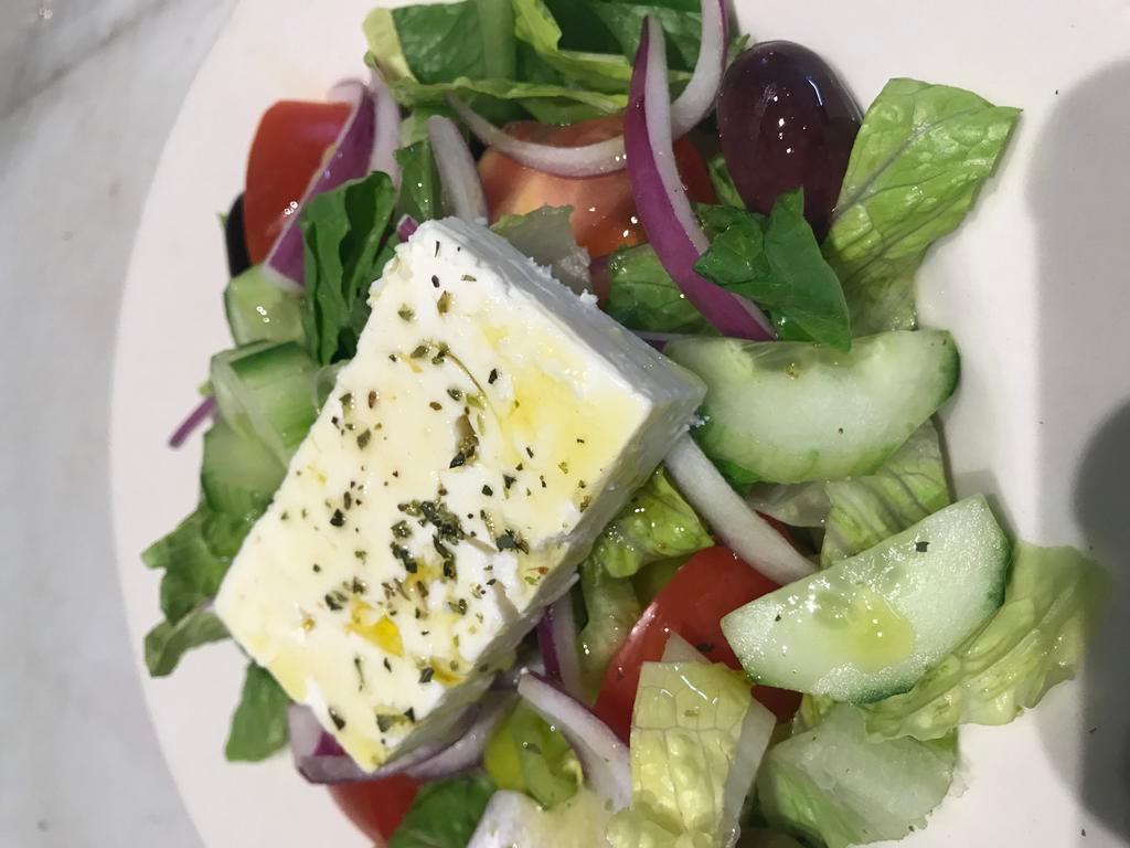 Heleniki Salad · Traditional Greek salad of romaine lettuce, tomatoes, cucumbers, green peppers, feta cheese and oregano mixed with house dressing.