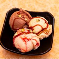 ICE CREAM  · Three scoops of ice cream served with chocolate sauce.