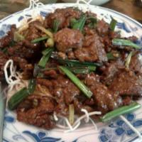 413. Mongolian Beef · Beef marinated with wine, sauteed with scallion and served on top of rice noodle. Hot and sp...