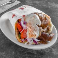 Gyro Sandwich · Sliced beef and lamb on a pita bread with onions,tomatoes , and  white sauce 
