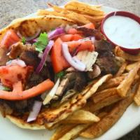 Greek Gyro Sandwich · Shredded pork  gyro on a pita with tomatoes, onions and white sauce