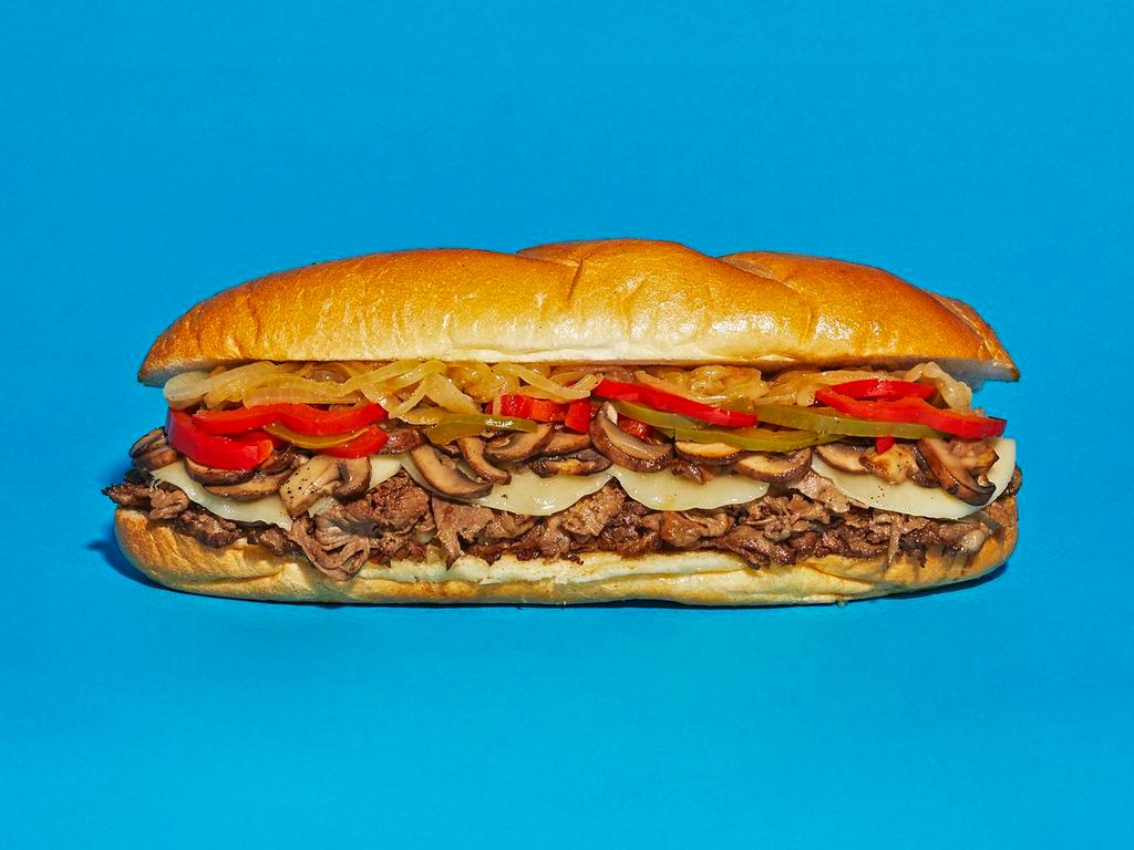 The Works Cheesesteak · Sliced steak with melted provolone, grilled onions, roasted bell peppers, and sauteed mushrooms on a hoagie roll.