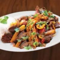 Lomo Saltado de Carne · Marinated strips of sirloin with onions, tomatoes, french fries, and other ingredients, and ...