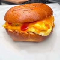Eggs and Cheddar Cheese · Served on a brioche bun with chipotle ketchup, sea salt & black pepper