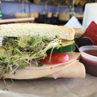 Turkey Veggie Avocado Sandwich · Sliced turkey, avocado, spinach, cucumber, tomato, sprouts and Italian dressing. Served with...