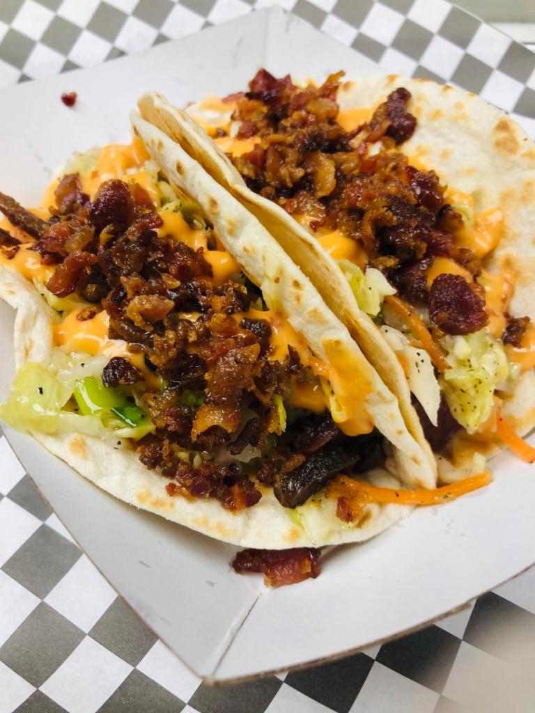 Irish Pig Taco · Spotted Cow braised corn beef, southern slaw, boom boom sauce and bacon crumbles.