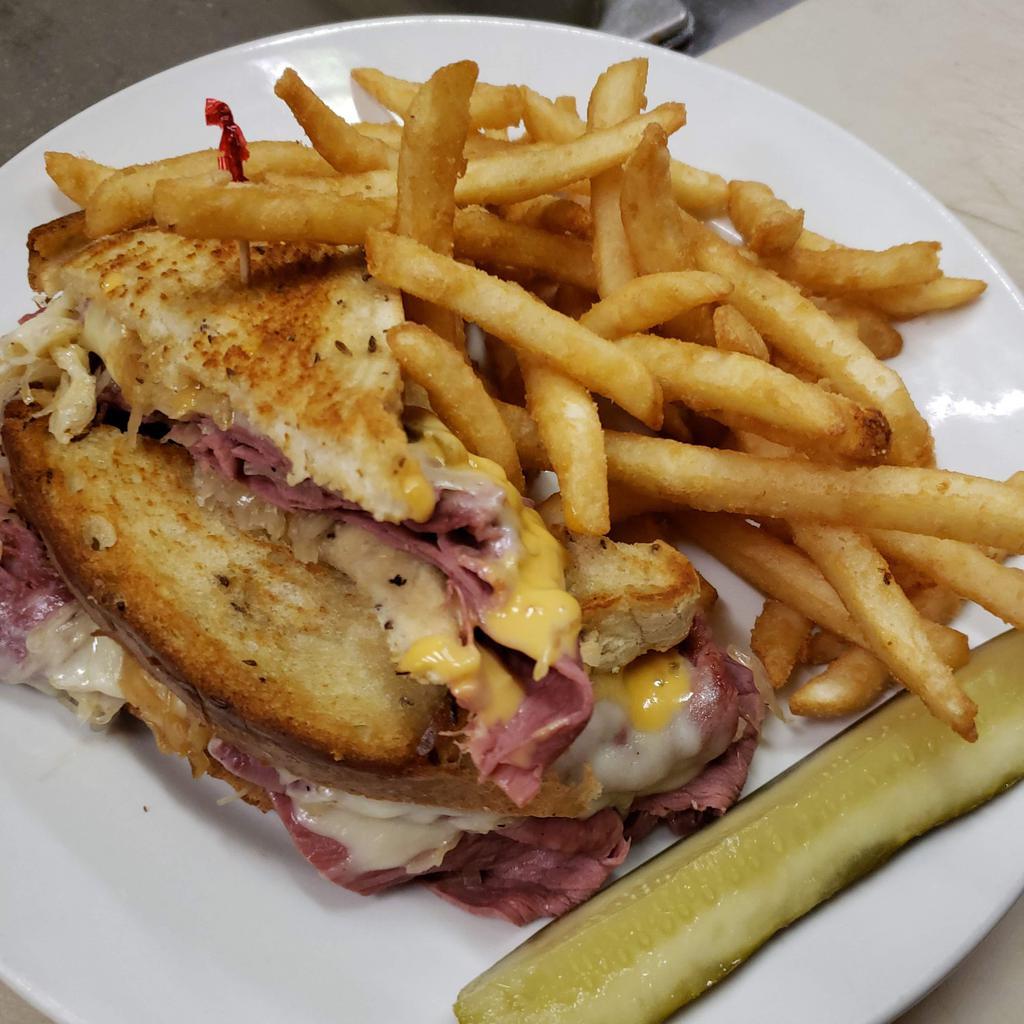 Reuben · Thinly sliced corned beef with sauerkraut, 1000 Island dressing, melted Swiss on toasted rye bread. Served with chips and a pickle.