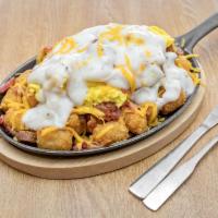 Country Style Skillet · Sausage, bacon, grilled ham, American cheese, our country gravy, topped with 2 eggs prepared...