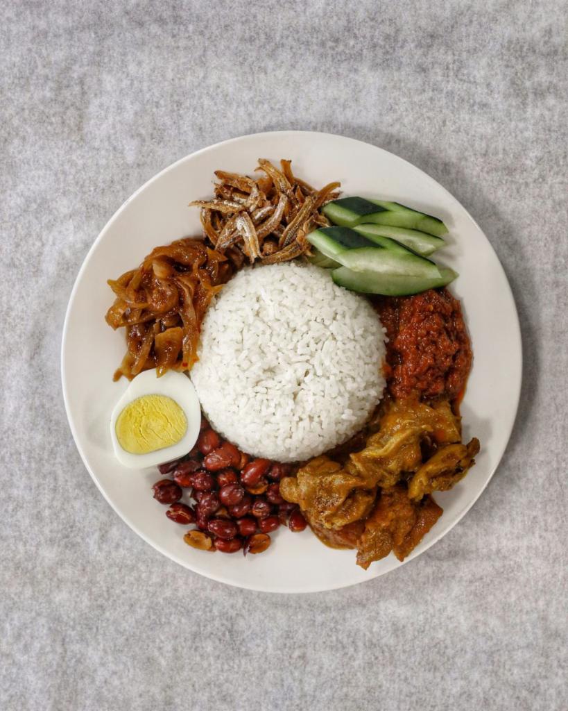 34. Nasi Lemak 椰浆饭 · Malaysian popular coconut rice served with egg, cucumber, anchovies, onion, sambal, peanut, curry chicken and potato. Spicy. 