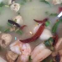 S6. Tom Yum Seafood โป๊ะแตก · With Thai herb, chili and lime juice. Spicy.