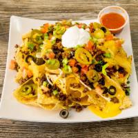 Nacho Supreme · Tortillas chips topped with nacho cheese, tomato, black olives, green onions, jalapenos and ...