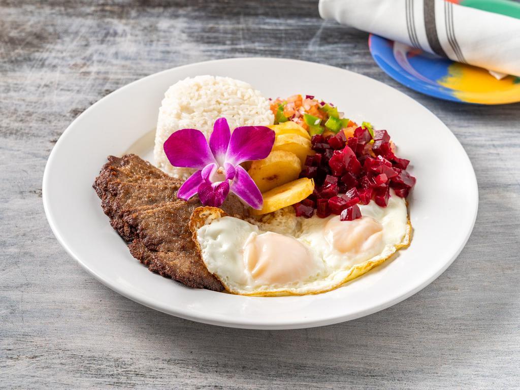 Silpancho · Lightly breaded beef, fried eggs, rice, beet salad, tomato, scallions, crispy potato and onions.