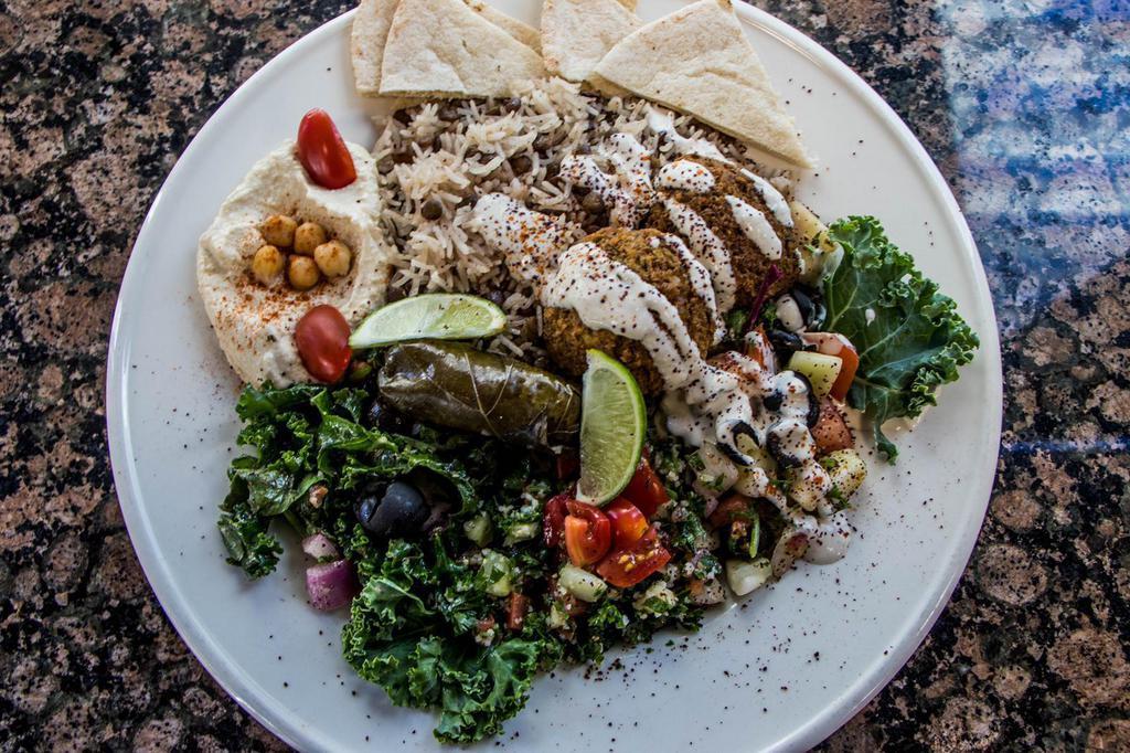 Greek Platter · Falafel with lentil rice, hummus, tabbouleh, cucumber salad, Greek salad, dolma, and pita bread.