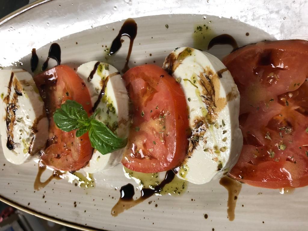 Caprese Insalate · Mozzarella and beefsteak tomatoes.