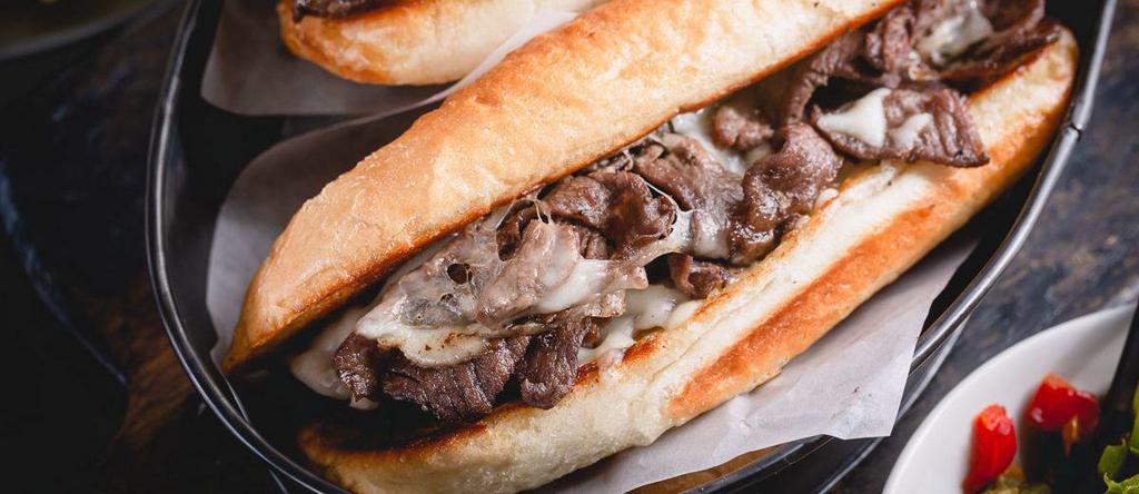 Philly Steak Sandwich · Tender seasoned steak, cheese, crisp lettuce, chopped onions, fresh tomatoes and topped with our special sauce.